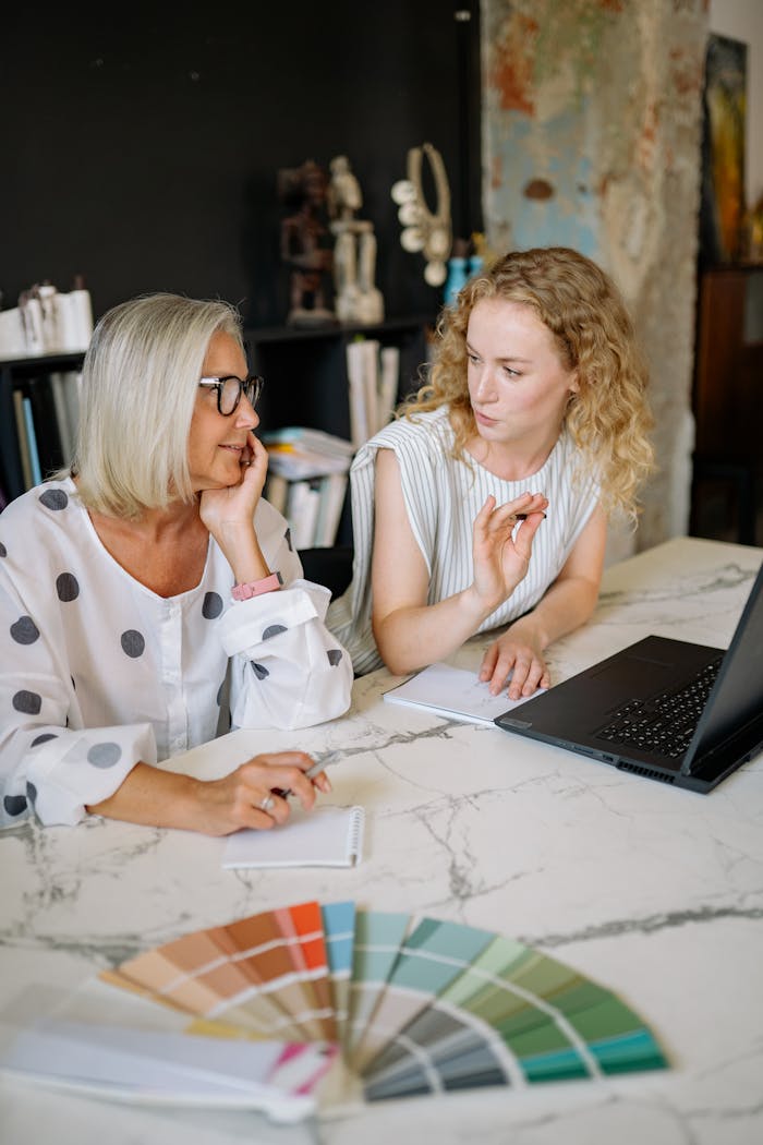 Two businesswomen discussing creative ideas in a modern office setting.